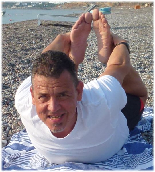 Yogalehrer Günter praktiziert den Bogen am Strand